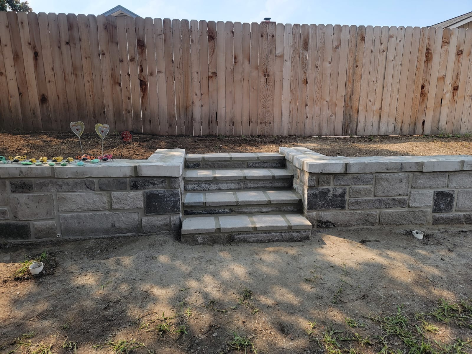 Retaining wall with centered stair access and capstones
