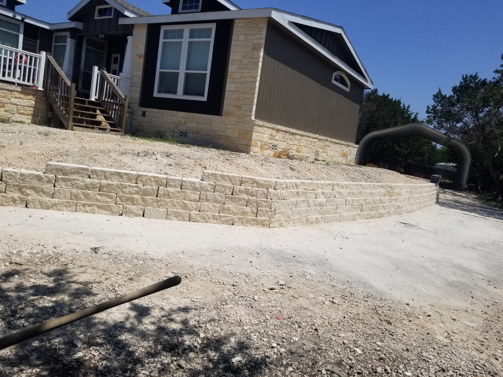 Curving stone retaining wall at the front of a property