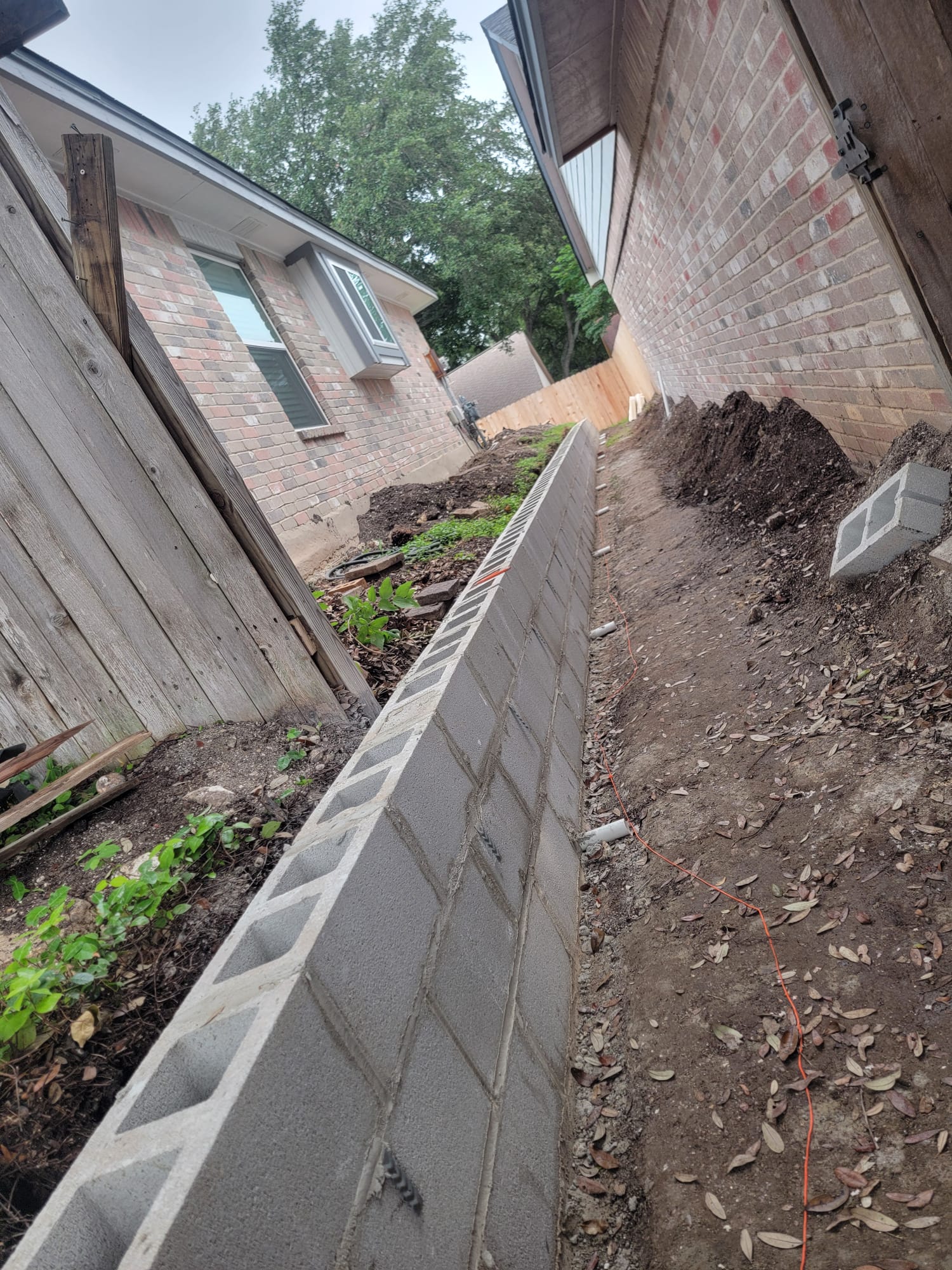 Long retaining wall foundation and block layout during construction